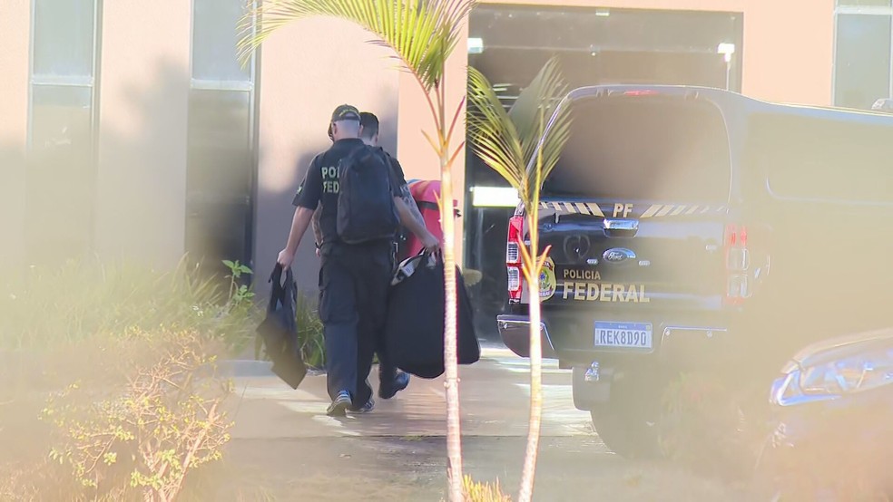 Policiais carregam malotes na superintendência da PF em Brasília — Foto: TV Globo/Reprodução