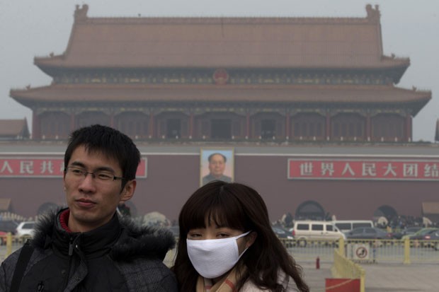 Chinesa utiliza máscara para se proteger do ar poluído registrado em Pequim (Foto: Ng Han Guan/AP)