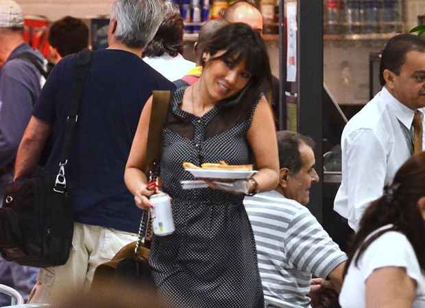 Multi-tarefas: Daniele Suzuki equilibra prato de refeição, latinha de refrigerante e celular (Foto: AgNews)