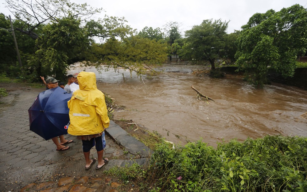 Moradores observam inundação causada pelo rio Masachapa após a passagem da tempestade tropical Nate, na Nicarágua (Foto: Inti Ocon/AFP)