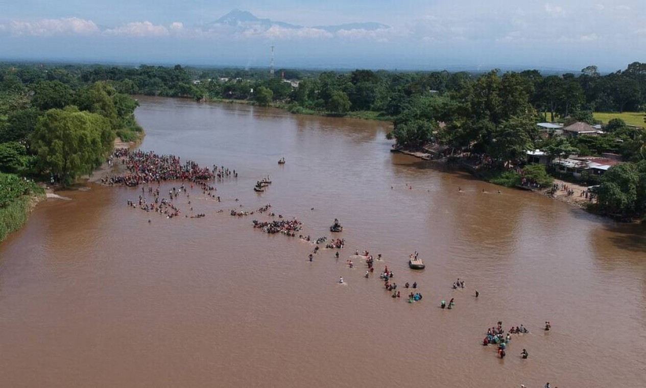 Imigrantes atravessam o rio Suchiate, de Tecun Uman, na Guatemala, a Ciudad Hidalgo, no México — Foto: CARLOS ALONZO / AFP - 29/10/2018 