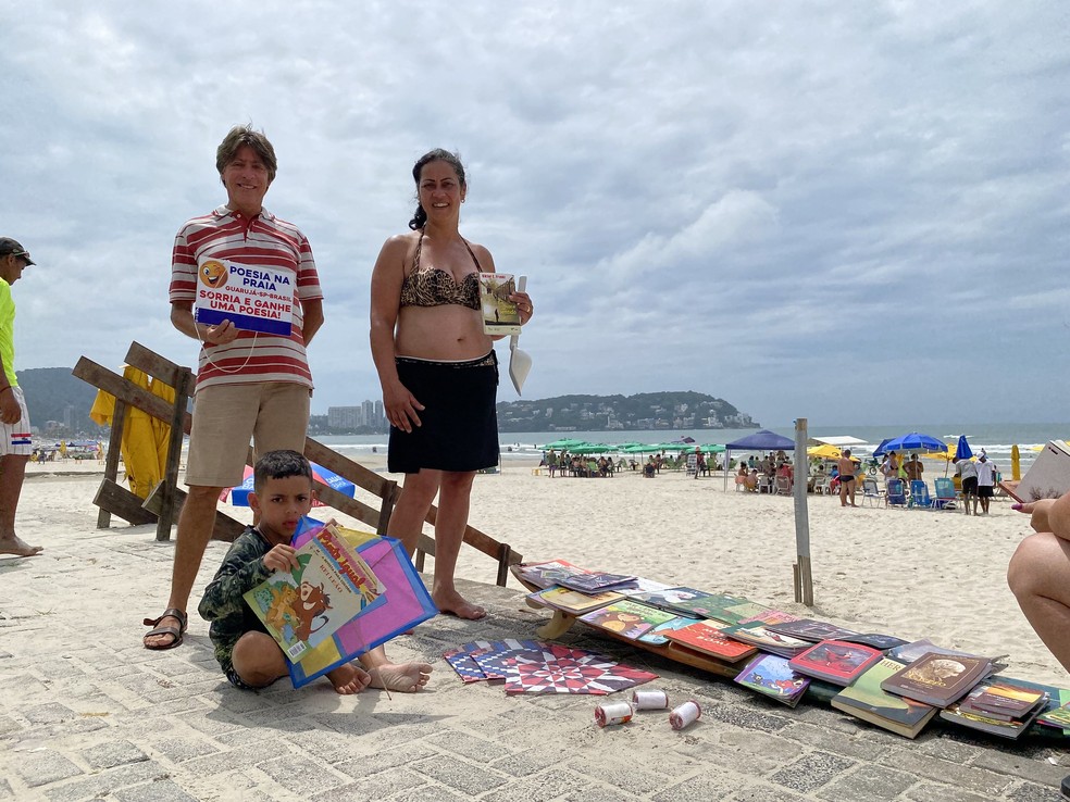 Fábio Rogério dedica seu tempo livre a troca de 'sorrisos por livros e poesias' em praia — Foto: Prefeitura de Guarujá/Divulgação