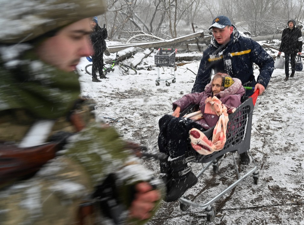 8 de maro - Equipe de resgate empurra um carrinho de compras idosa durante a evacuao de civis da cidade de Irpin, na Ucrnia — Foto: Sergei Supinsky/AFP