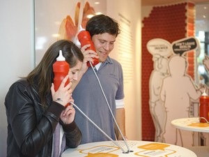 Visitantes escutam informações em fone em forma de ketchup no Museu do Currywurst, em Berlim (Foto: Divulgação/Currywurst Museum)