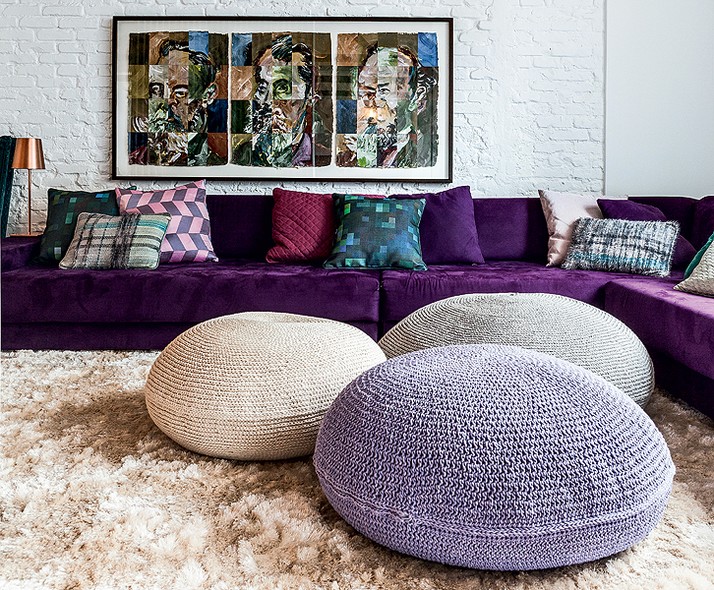 A sala de TV do arquiteto Thiago Passos ficou marcante com o sofá púrpura e os pufes de crochê (um deles em lilás)
