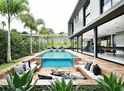 Com 420 m², a casa projetada por Luis Café e Vivian Contri tem quatro suítes, cozinha gourmet integrada com a área de jogos, living, lareira externa e piscina