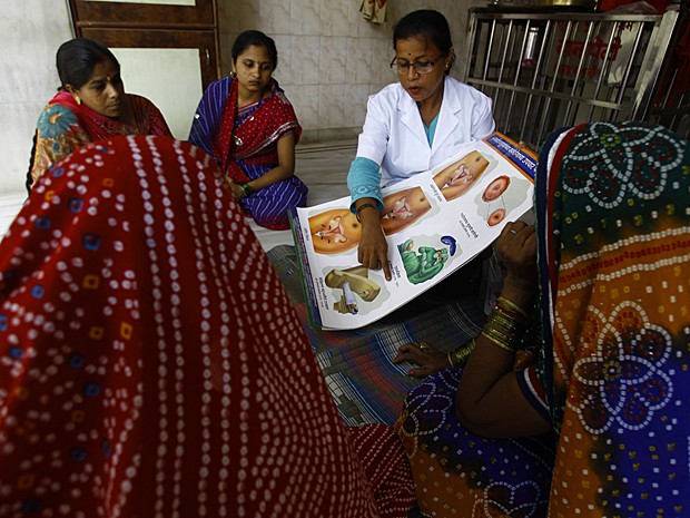 Profissional da saúde fala sobre câncer do colo do útero para mulheres em Mumbai (Foto: Rafiq Maqbool/AP)