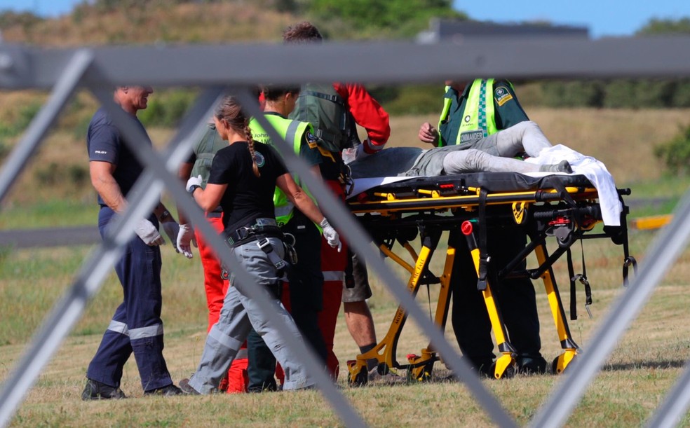 Equipes de resgate atendem uma pessoa ferida na erupção do vulcão da Ilha Branca durante chegada em Whakatane, na Nova Zelândia — Foto: Alan Gibson/New Zealand Harold via AP