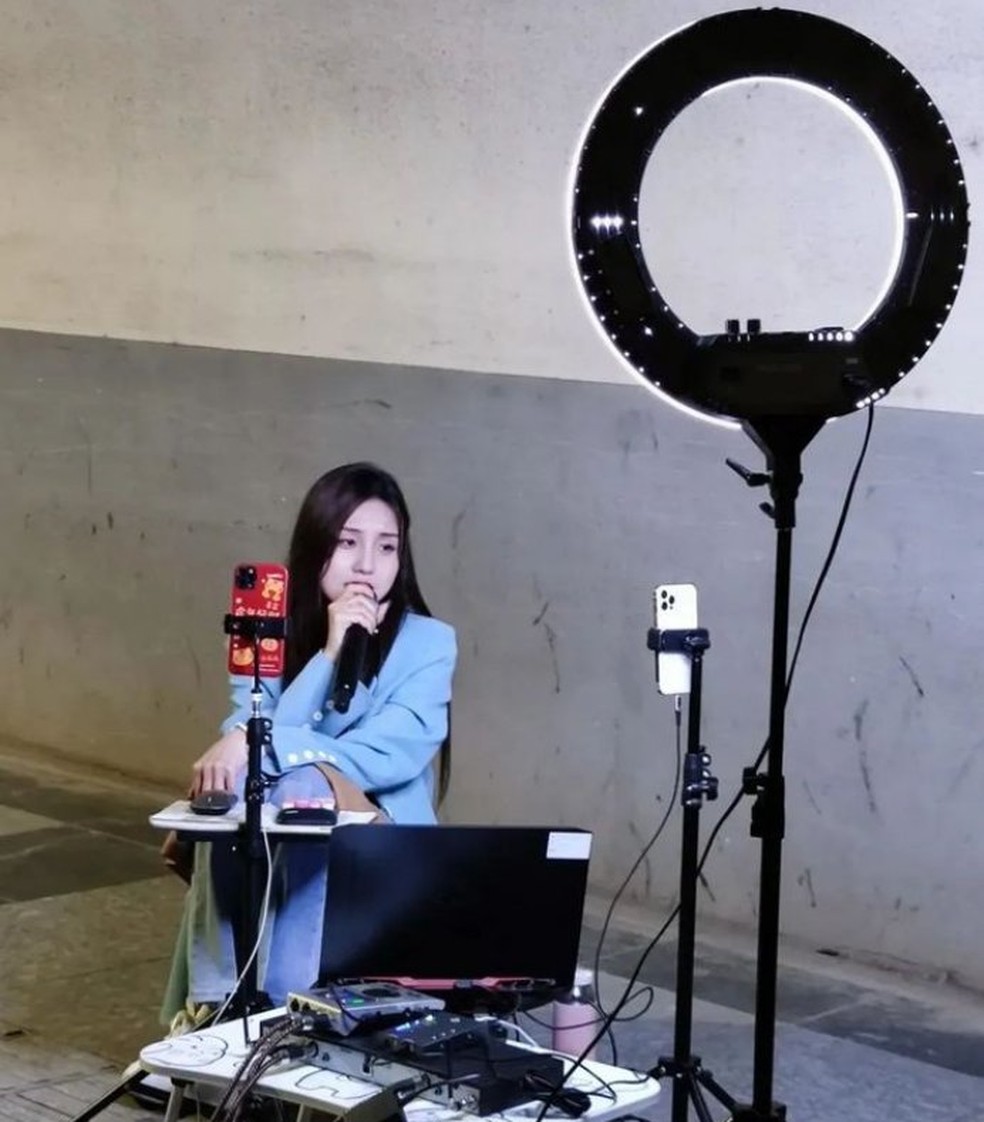 Influenciadoras usam celulares, computadores, refletores e microfones em suas transmissões ao vivo nas ruas da China — Foto: Reprodução/Twitter