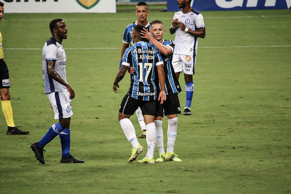 Pedro Lucas recebe cumprimentos de Guilherme Azevedo após o pênalti para o Grêmio — Foto: Lucas Bubols/ge