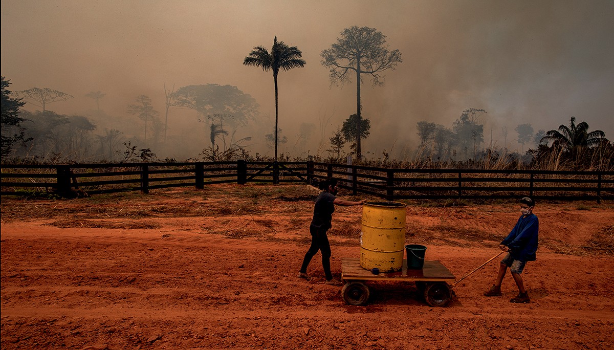 Membros do assentamento 12 de outubro, em Cláudia, Mato Grosso, tentam apagar o fogo de queimadas ilegais em uma reserva ambiental na floresta Amazônica (Foto: Fernanda Liguabue e Victor Moriyama)