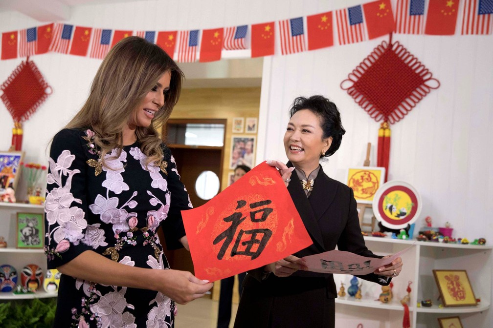 A primeira-dama dos EUA, Melania Trump, observa lição de caligrafia em que foi escrita a palavra 'Sorte' durante visita a uma escola em Pequim, acompanhada pela primeira-dama da China, Peng Liyuan (Foto: Ng Han Guan/Reuters/pool)