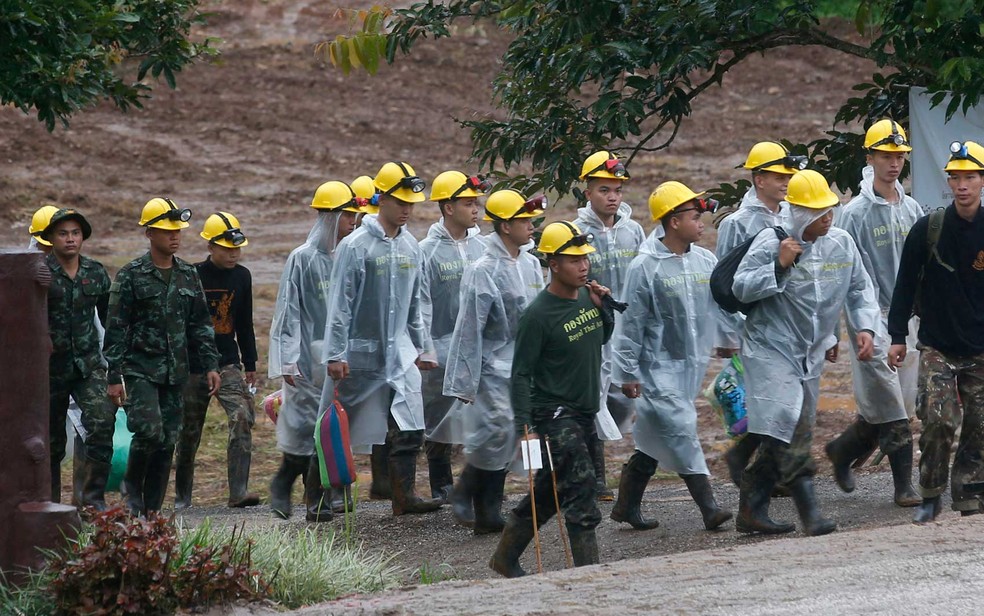 Equipes de resgate usam capas contra a chuva (Foto: Sakchai Lalit / AP Photo)