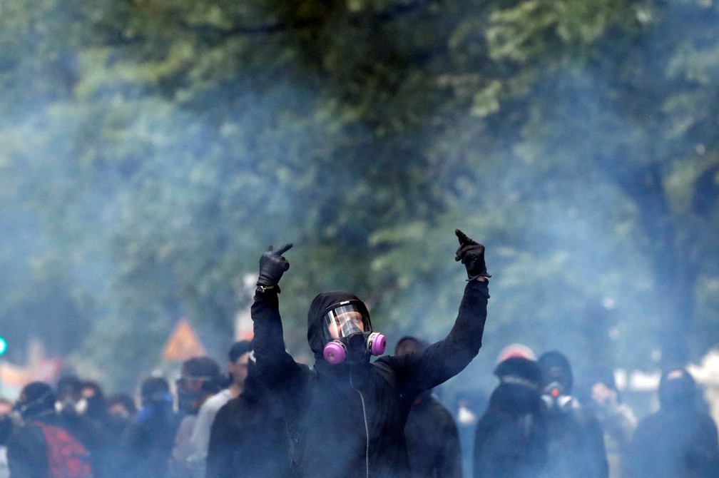 Mascarado em protesto no Dia do Trabalho em Paris (Foto: Christian Hartmann/Reuters)