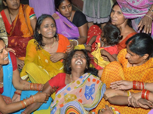 Mulheres choram a morte de um familiar que foi esmagado por uma parede que desmoronou durante terremoto desta terça-feira (12) em Patna, na índia (Foto: AP/Press Trust of India)