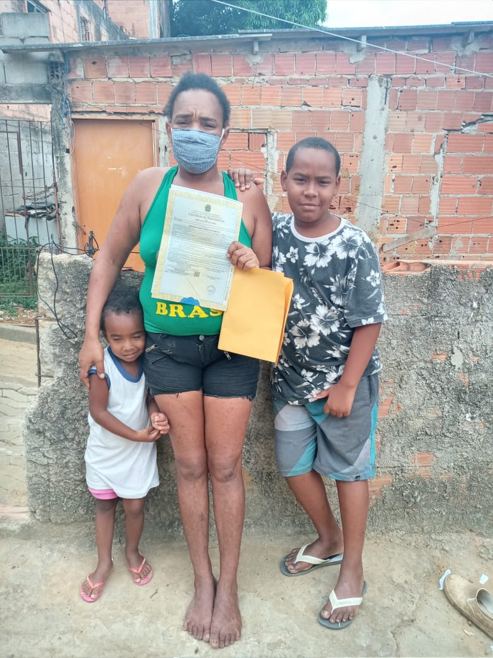 Adna Mateus Oliveira segurando a certidão de nascimento do filho, José Aldo Oliveira, de nove anos — Foto: Divulgação