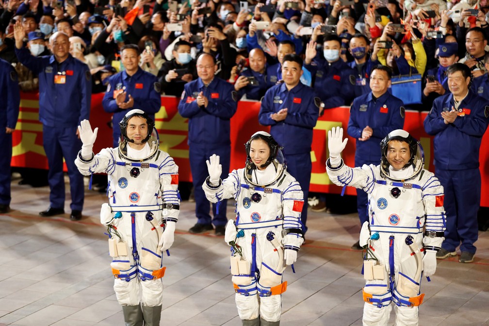 Astronautas  Ye Guangfu, Zhai Zhigang e Wang Yaping acenam em cerimônia antes do lançamento do foguete Longa Marcha-2F Y13, levando a espaçonave Shenzhou-13 com eles na segunda missão tripulada da China para construir sua própria estação espacial. Cerimônia foi no Centro de Lançamento de Satélites de Jiuquan, na província chinesa de Gansu, no dia 15 de outubro. — Foto: Carlos Garcia Rawlins/Reuters