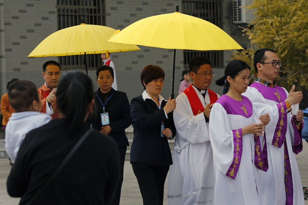 Padres e fiéis durante procissão em igreja católica em Saiqi, na China — Foto: AP Photo/Andy Wong