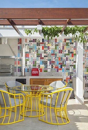 Espaço da churrasqueira, com azulejos bem coloridos e mesa para refeições (Foto: Divulgação)