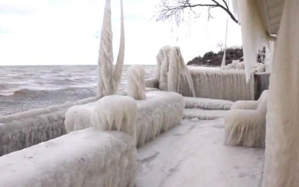 A casa fica de frente para o lago e teve todo o exterior molhado; até uma poltrona na varanda foi coberta de gelo (Foto: John Kucko)