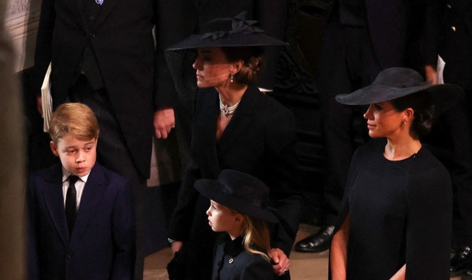 Princesa Kate, ao lado de seus dois filhos mais velhos, George e Charlotte, e de Meghan Markle, mulher do príncipe Harry
