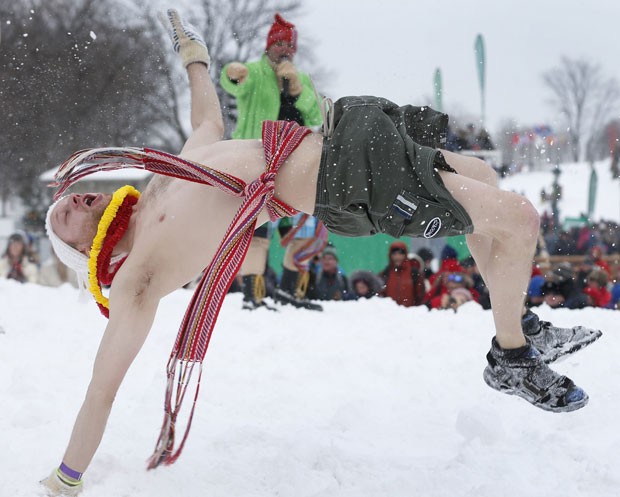 A man does somersaults in the snow during a winter carnival in temperatures of -4ºC (Photo: Mathieu Bélanger/Reuters)