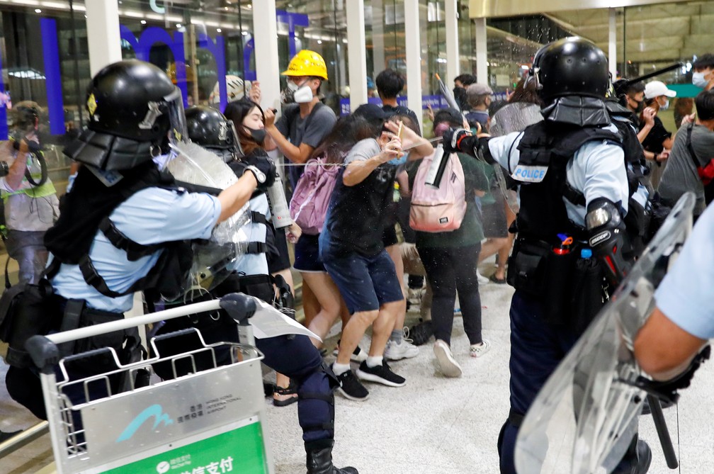 Polícia usa spray de pimenta para dispersar os manifestantes dentro do aeroporto de Hong Kong nesta terça-feira (13). — Foto: Tyrone Siu/Reuters