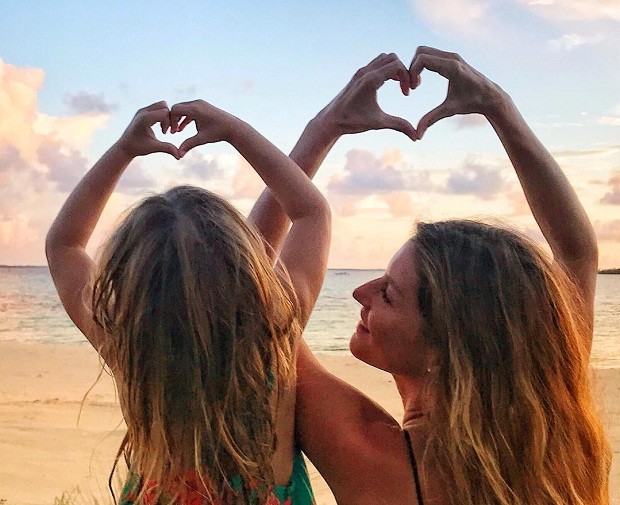 Gisele e Vivian fazem corações com as mãos em praia (Foto: Reprodução/Instagram)