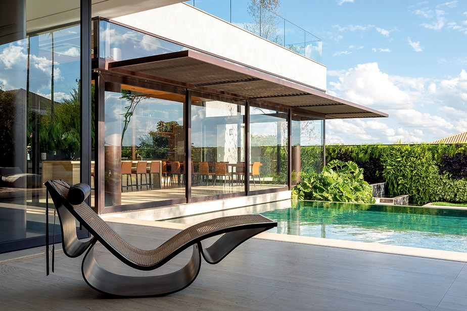 No projeto do escritório Ge Carolo Arquitetura, com paisagismo de Mônica Costa, a cadeira de balanço 'Rio', de Oscar Niemeyer para a Etel Design, convida à contemplação