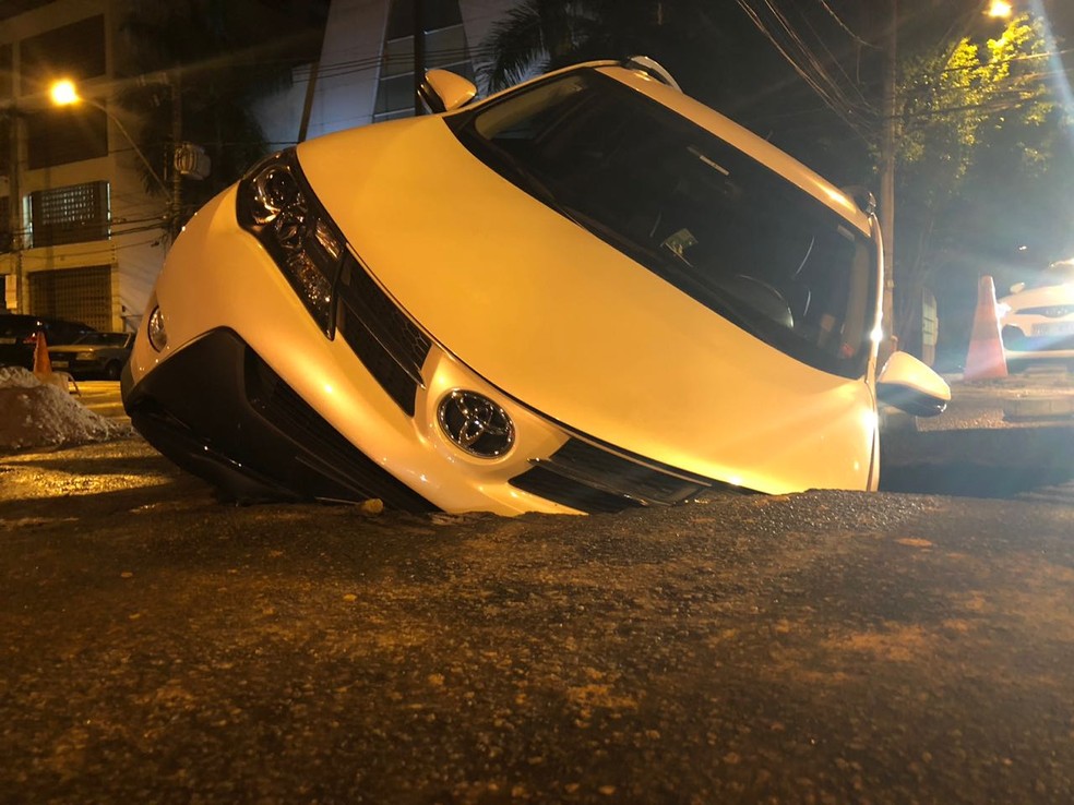 Carro caiu em cratera na frente de igreja na Praia do Canto (Foto: Rodrigo Maia/TV Gazeta)
