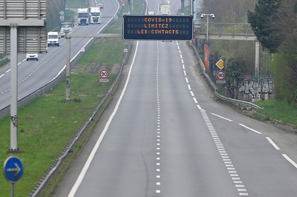 Estrada vazia na França com painel que pede para que se evite contatos, em 19 de março de 2020 — Foto: Damien Meyer / AFP