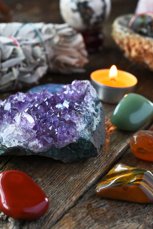 A close up image of chakra crystals surrounding am amethyst geode cluster. (Foto: Getty Images/iStockphoto)