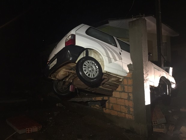 Carro foi parar em cima de muro com a enxurrada em Manfrinópolis  (Foto: Michele Arenza / RPC )