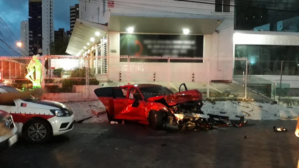 Motorista do carro de luxo vermelho fugia da polícia quando bateu em outro carro em um cruzamento em Manaíra, João Pessoa — Foto: Yanka Oliveira/TV Cabo Branco