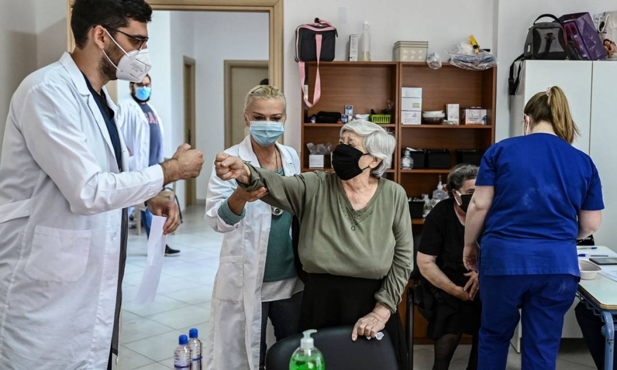 Paciente cumprimenta um membro da equipe médica no centro de saúde da ilha grega e Elafonissos, depois de receber dose da vacina contra Covid-19 — Foto: ARIS MESSINIS / AFP
