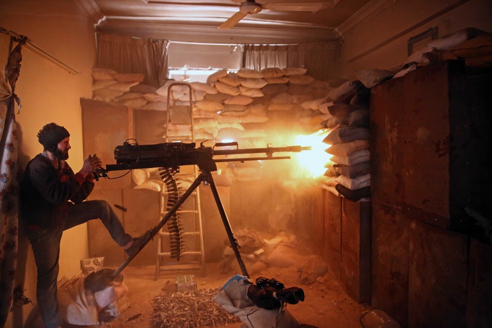 Combatente da brigada Failaq al-Rahman faz disparos a partir de distrito dominado pelos rebeldes na região leste de Damasco, na Síria (Foto: Amer Almohibany / AFP)