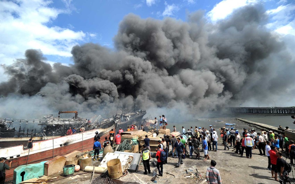 Bombeiros tentam extinguir incêndio em barcos de pesca no porto de Benoa, em Denpasar, na ilha balneária de Bali (Foto: Sonny Tumbelaka / AFP Photo)