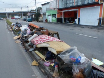 Objetos perdidos pelos moradores ainda estão entulhados em uma rua da CIC (Foto: Thais Kaniak / G1 PR)