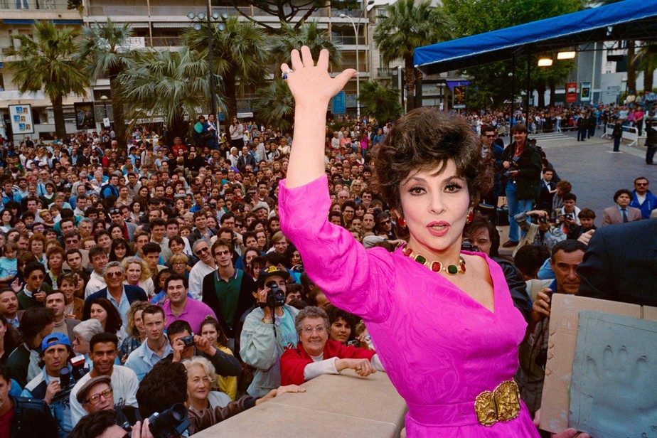 A atriz Gina Lollobrigida acena para multidão no Festival de Cannes, em 1991