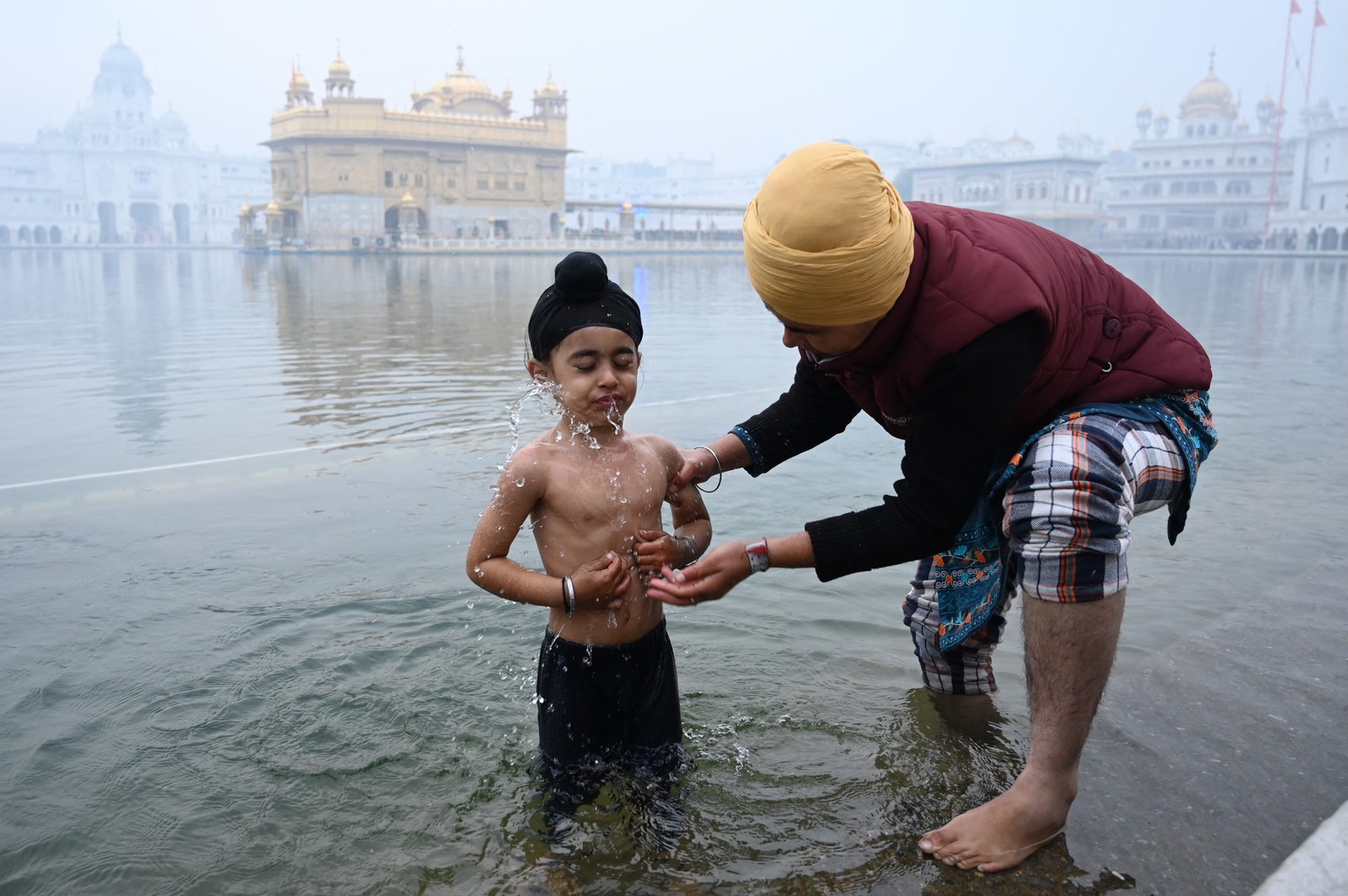 Jovem Sikh participa de ritual em comemoração ao nascimento do 10º Guru dos Sikhs Guru Gobind Singh, no Templo Dourado em Amritsar — Foto: NARINDER NANU/AFP