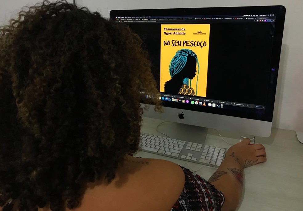 Mulher observando capa do livro "No seu pescoço" da escritora nigeriana Chimamanda Ngozi Adichie — Foto: Ana Kézia Gomes/G1