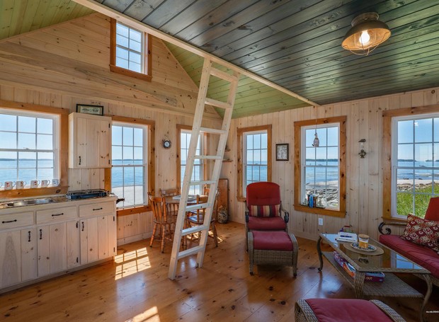 A pequena casa isolada possui sala, mini cozinha e jantar integrados (Foto: Coldwell Banker / Reprodução)