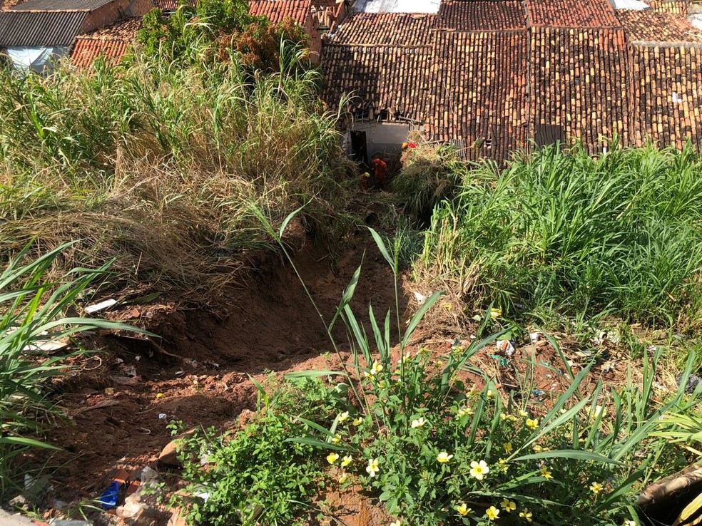 Barreira deslizou nos fundos de uma casa no Bebedouro, em Maceió; uma mulher foi soterrada — Foto: Sofia Sepreny/G1