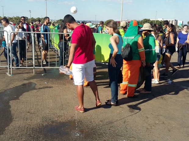 Torcedor esvazia garrafa de água antes de entrar no Mané Garrincha; líquidos não podem ser levados para dentro da arena (Foto: Pedro Borges/G1)