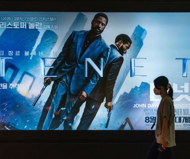 SEOUL, SOUTH KOREA - 2020/08/26: A woman wearing a protective mask walks by a billboard of the movie 'TENET'. 'TENET' directed by Christopher Nolan is released on 26 August in South Korea for the first time in the world. (Photo by Simon Shin/SOPA Images/L (Foto: SOPA Images/LightRocket via Gett)