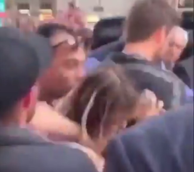 A cantora Miley Cyrus sendo agarrada e beijada por um homem durante passeio dela com o marido pelas ruas de Barcelona (Foto: Twitter)