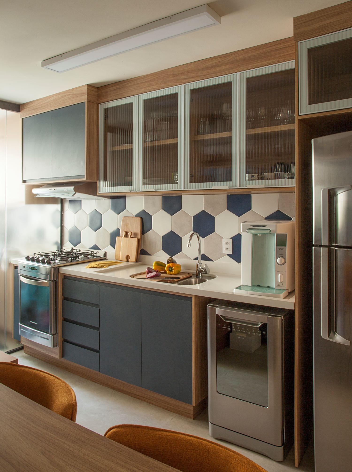 COZINHA | O novo layout da cozinha permite interagir com as pessoas no living. O piso do ambiente é o Stelle Grigio, da Portobello. Revestimento hexagonal azul, cimento e white, da Ceral (Foto: Divulgação / Luis Gomes)