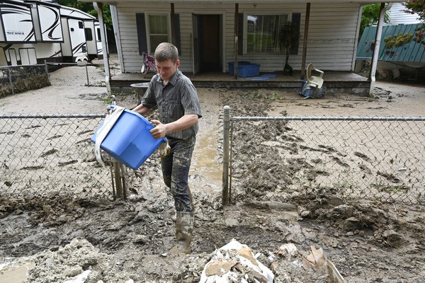 Voluntário ajuda a retirar pertences de casa atingida por inundações em Hindman, no Kentucky, em 31 de domingo 2022. — Foto: Timothy D. Easley/ Associated Press