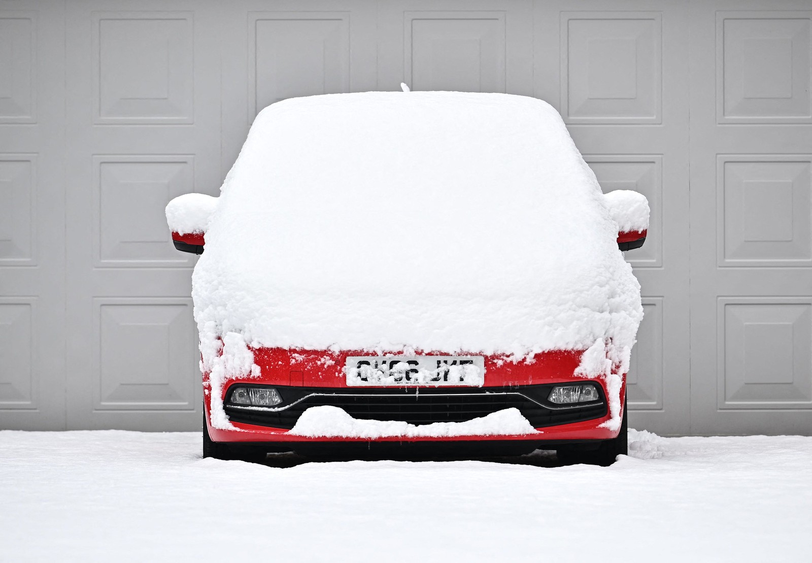 A neve cobre um carro estacionado em uma garagem em Brenchley, sudeste da Inglaterra — Foto: Ben Stansall / AFP