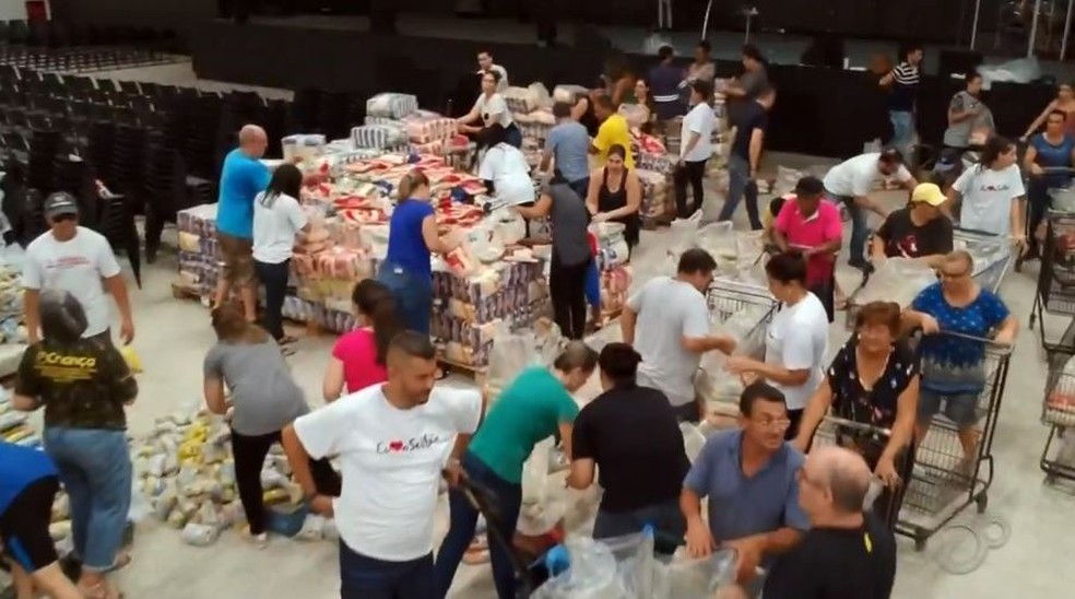 Cerca de 600 voluntários trabalharam em galpão para embalar as cerca de 48 toneladas de alimentos arrecadadas — Foto: TV TEM/Reprodução